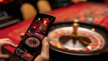 A cheerful woman in traditional clothing using her smartphone during a festive moment, showing how easily the 4777BET1 app fits into everyday life.
